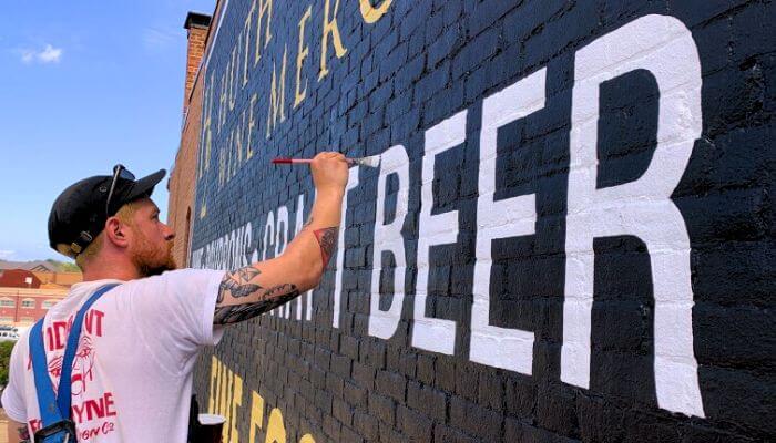 man-hand-painting-business-sign